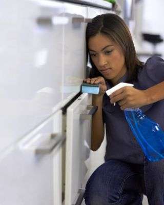 woman looking at the top of a drawer cleaning it down to the last spec of dust