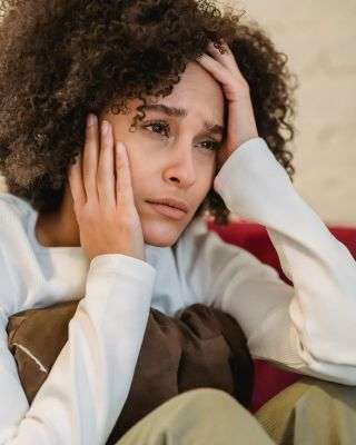 woman with her head in her hands looking anxious and wanting to give up