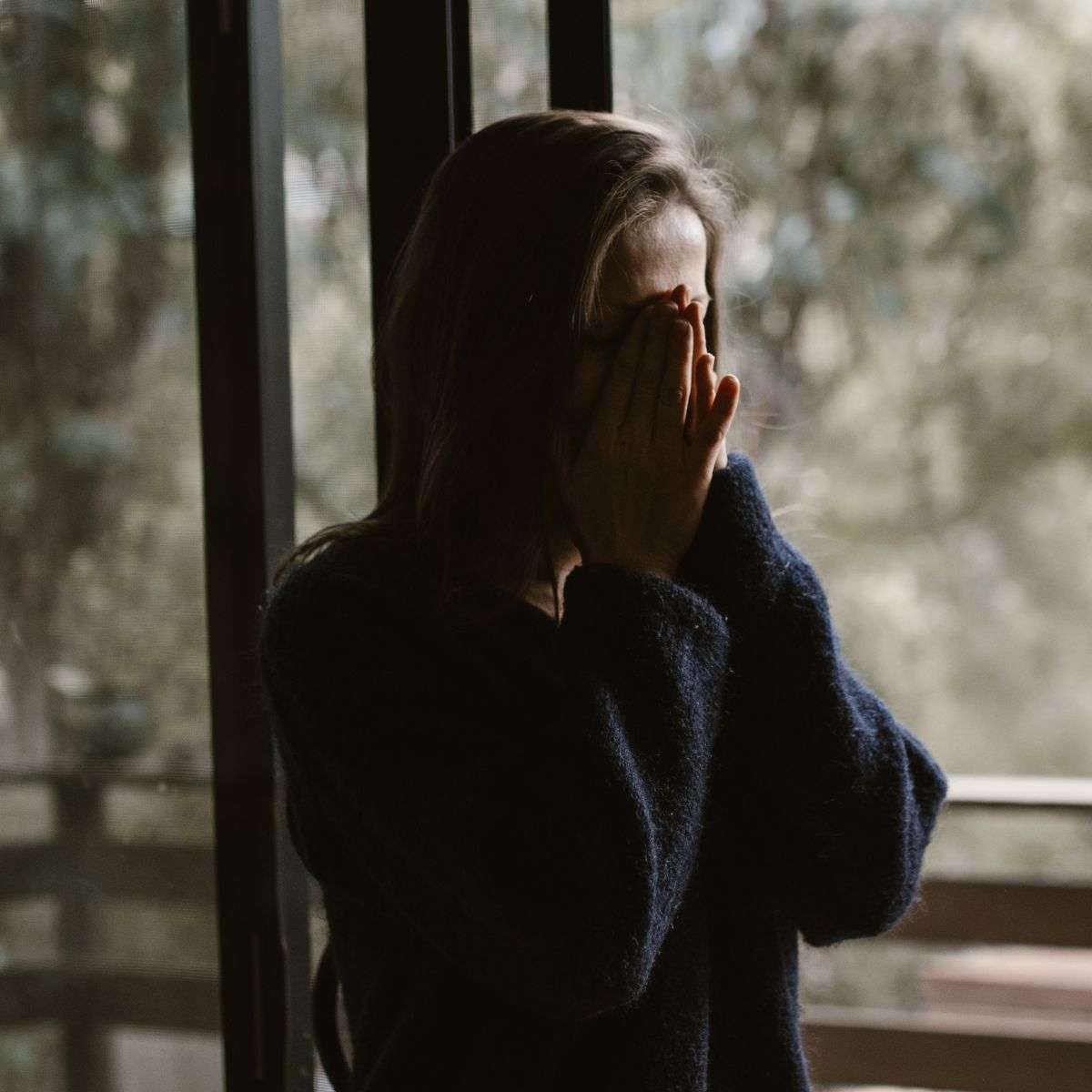 Mindful Healing PTSD Therapy in New Jersey woman in the shadows crying into her hands