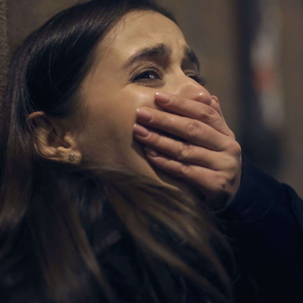 Mindful Healing Panic Attack Treatment in New Jersey young woman backed up against a wall, crying, with her hand over her mouth panicking