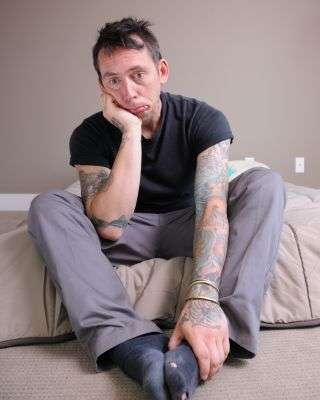 man sitting down looking frazzled and not connected to reality