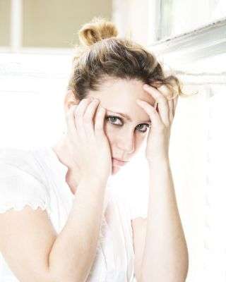 woman with her hands up by her face looking afraid