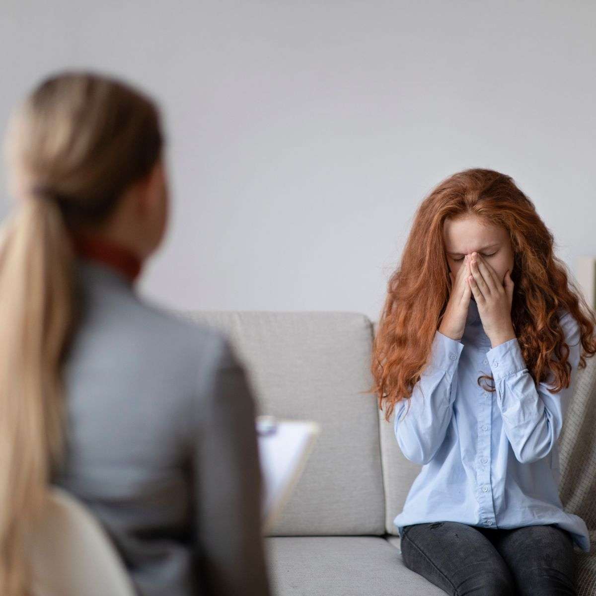 Mindful Healing Self Harm Treatment in New Jersey Young red-head teen girl speaking to a counselor about her struggles