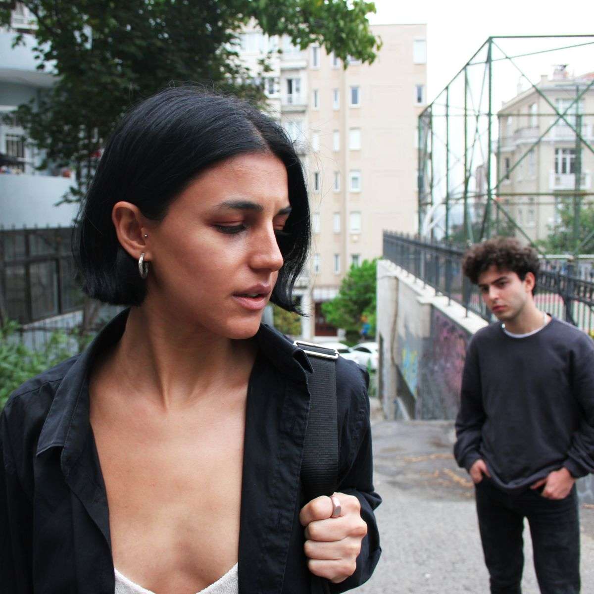 Mindful Healing Trauma Treatment in New Jersey scared young woman walking and looking over her shoulder to see that a young man is following her