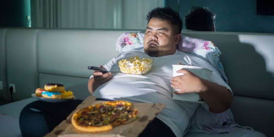 Mindful Healing Overweight man surrounded by food obviously depressed who could benefit from NJ eating disorder treatment